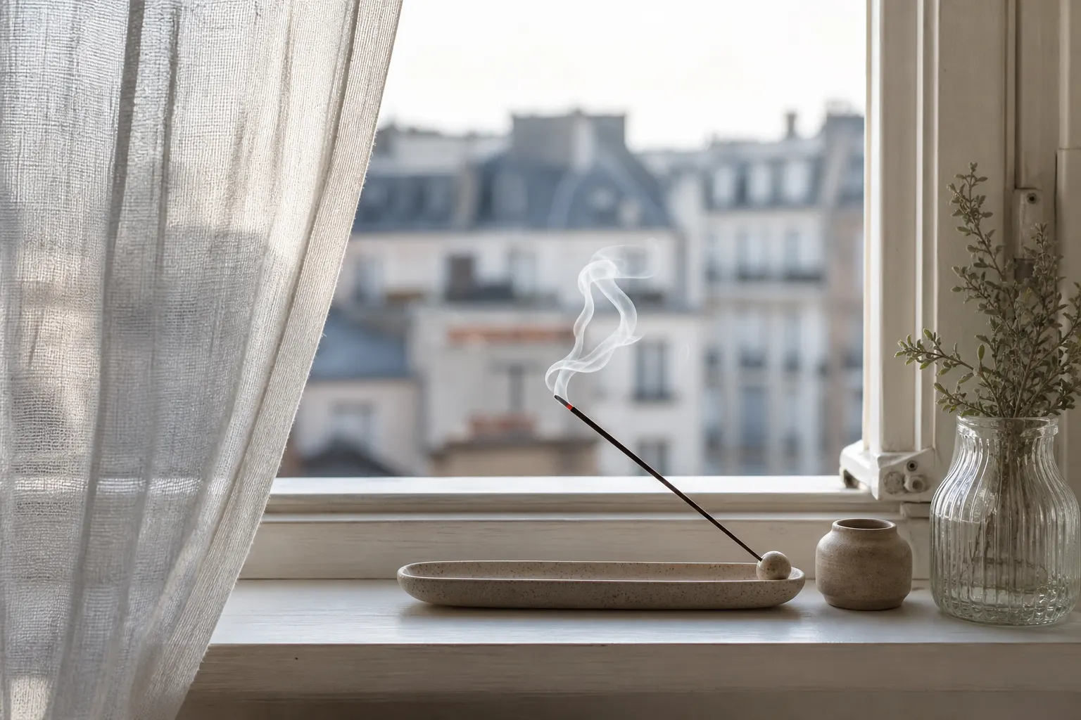 Support d’encens sur un rebord de fenêtre ouverte, air frais en appartement